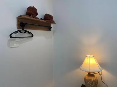 a teddy bear sitting on a shelf next to a lamp at MONDEE House @The Airport in Thalang