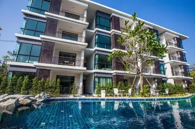 a building with a swimming pool in front of it at The Title Beach Front in Rawai Beach