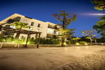 a large white building on a street at night at The Title Beach Front in Rawai Beach