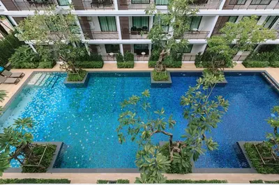 a large blue swimming pool in the middle of a building at The Title Beach Front in Rawai Beach