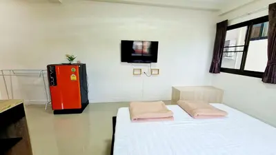 a room with a bed and a red refrigerator at TP House@Naka in Phuket Town