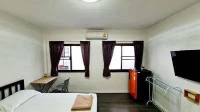 a bedroom with a bed and a tv and window at TP House@Naka in Phuket Town