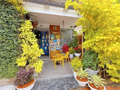 a patio with potted plants and tables and chairs at Ideo Phuket Hotel - Naiyang Beach in Nai Yang Beach