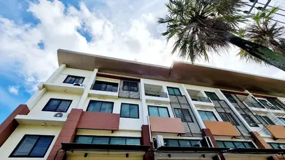 a tall building with windows and a palm tree at TP House at town in Phuket Town