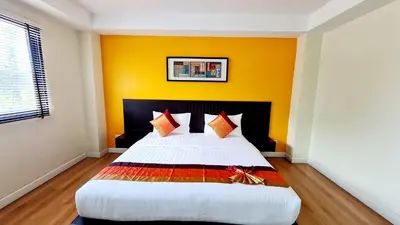 a bedroom with a large bed with yellow walls at TP House at town in Phuket Town