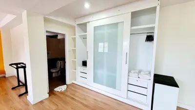 a walk in closet with white cabinets and a glass door at TP House at town in Phuket Town
