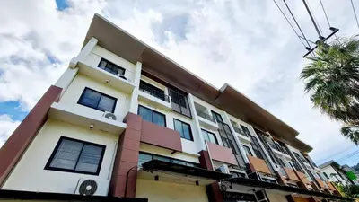 a white and pink building with a palm tree at TP House at town in Phuket Town