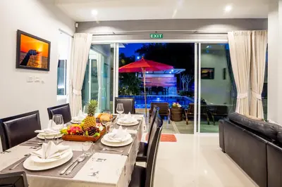 a dining room with a table with chairs and an umbrella at 3 Bedroom Exclusive Private Pool Villa Smooth as Silk in Ao Nang Beach