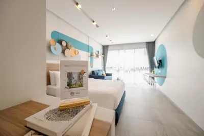 a room with a bed and a table with a book at HOMA Phuket Town in Phuket Town
