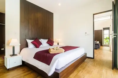 a bedroom with a large white bed with red pillows at Shanti Villas x MonthStayZ Thailand in Rawai Beach