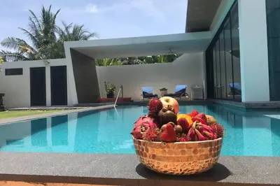 a basket of fruit sitting next to a swimming pool at Villa MAI MEE PAN HA 3 bedrooms in Nai Yang Beach