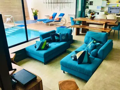 a living room with two blue couches and a table at Villa MAI MEE PAN HA 3 bedrooms in Nai Yang Beach