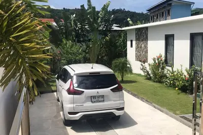 a white car parked in front of a house at Villa MAI MEE PAN HA 3 bedrooms in Nai Yang Beach