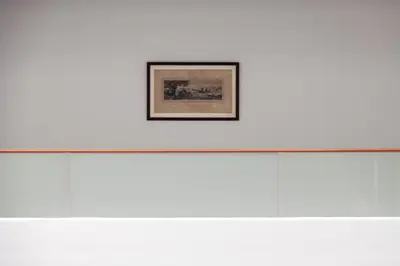 a framed picture on a white wall in a museum at Anona Beachfront Phuket Resort-SHA EXTRA PLUS in Patong Beach