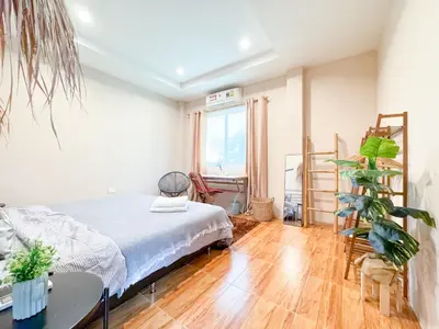 a bedroom with a bed and a table and a plant at Sea Dreamer Beachfront Apartments in Phuket Town