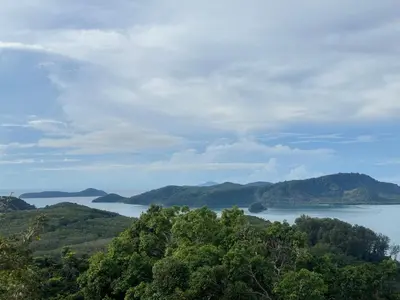a view of a large body of water with mountains at Sea Dreamer Beachfront Apartments in Phuket Town