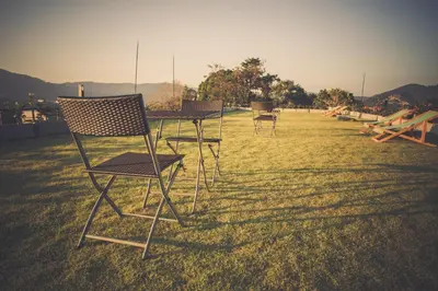 three chairs and a table in the grass at Studio apartments on a hill in Kathu