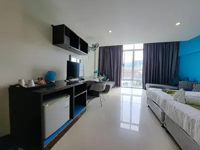 a hotel room with a bed and a desk in it at Baan Oui guest house - Nai Harn in Phuket Town