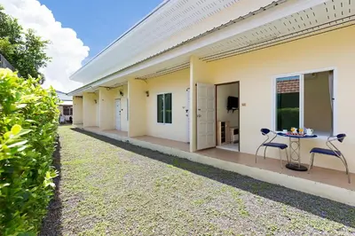 a side view of a house with a table and chairs at RAWAÏ Bedroom and kitchen in Rawai Beach