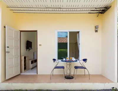 a patio with a table and two chairs and a door at RAWAÏ Bedroom and kitchen in Rawai Beach