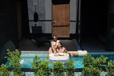 two men in a bath tub in a swimming pool at AKRA Collection Layan - Hideaway Villas in Layan Beach