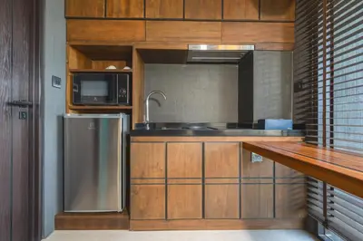 a kitchen with a sink and a microwave at AKRA Collection Layan - Hideaway Villas in Layan Beach