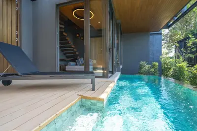 an infinity pool in the backyard of a house at AKRA Collection Layan - Hideaway Villas in Layan Beach