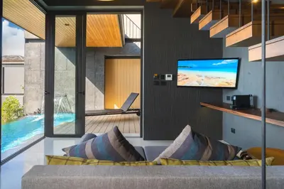 a living room with a couch and a tv at AKRA Collection Layan - Hideaway Villas in Layan Beach