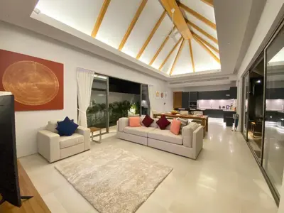 a living room with two couches and a dining room at Anchan Grand Residence Villa in Phuket Town