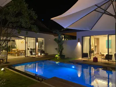 a swimming pool in a backyard at night at Anchan Grand Residence Villa in Phuket Town