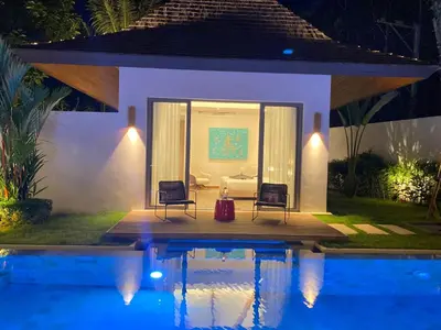 a villa with a swimming pool at night at Anchan Grand Residence Villa in Phuket Town