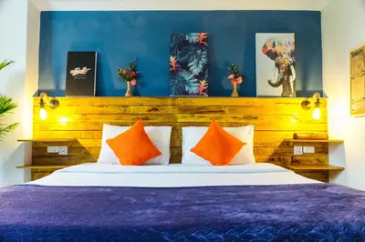 a bedroom with a purple bed with orange pillows at BH Baan Paradise Hotel Patong in Patong Beach
