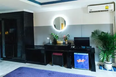 a room with a desk with a mirror and a sink at BH Baan Paradise Hotel Patong in Patong Beach