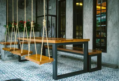 a table with two benches and a table with swings at BH Baan Paradise Hotel Patong in Patong Beach
