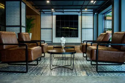 a lobby with leather chairs and a coffee table at BH Baan Paradise Hotel Patong in Patong Beach