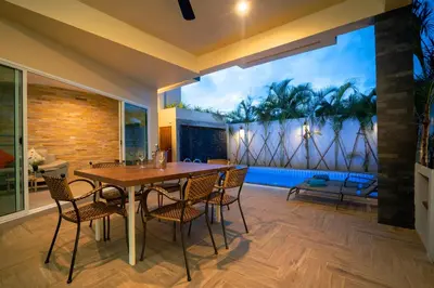 a dining room with a wooden table and chairs at Sabai Villas, 7 min drive from Naiharn & Rawai, Private pool, Four villas available in Rawai Beach