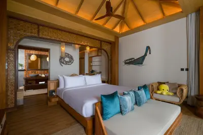 a bedroom with a large bed and a couch at SINAE Phuket Luxury Hotel in Phuket Town