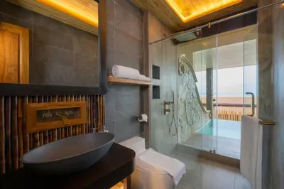 a bathroom with a black sink and a toilet at SINAE Phuket Luxury Hotel in Phuket Town