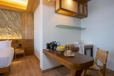 a kitchen with a wooden table in a room at SINAE Phuket Luxury Hotel in Phuket Town