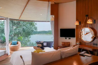 a bedroom with a large bed with a large window at SINAE Phuket Luxury Hotel in Phuket Town