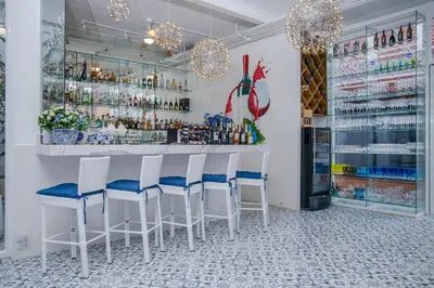 a bar with white chairs and a counter with drinks at Royal Thai Villa Phuket - SHA Extra Plus in Rawai Beach