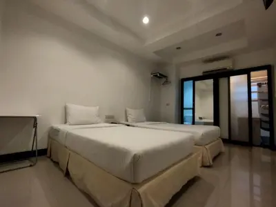 two beds in a room with two windows at The Auto Place in Ban Sam Kong