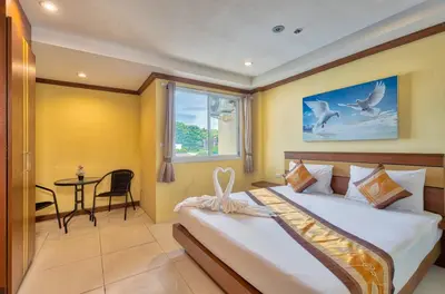 a bedroom with a large bed and a window at TJ Patong Hotel - Otop Shopping Paradise in Patong Beach