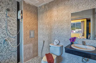 a bathroom with a toilet and a sink and a mirror at TJ Patong Hotel - Otop Shopping Paradise in Patong Beach