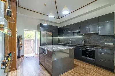 a kitchen with black cabinets and a counter top at Villa Stan in Kamala Beach
