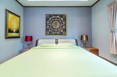 a bedroom with a large white bed with two lamps at Villa Stan in Kamala Beach