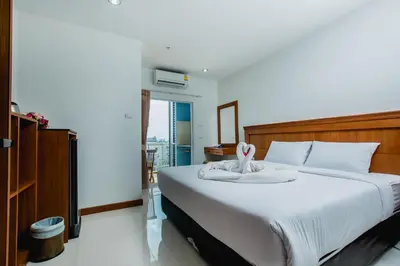 a bedroom with a large bed with white sheets at Aim House in Patong Beach