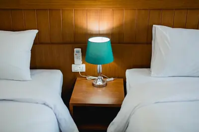 a room with two beds with a lamp and a phone at Aim House in Patong Beach