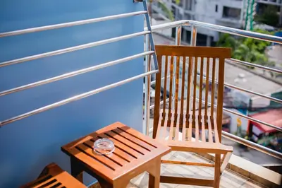 a wooden chair sitting on top of a balcony at Aim House in Patong Beach