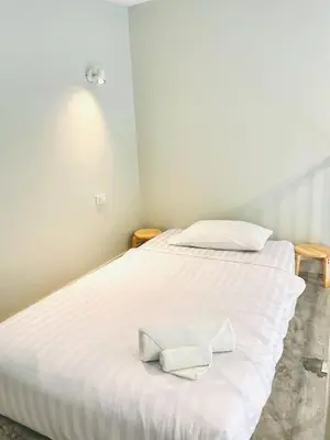 a white bed with two white towels on it at THE BELONG BOUTIQUE HOTEL in Phuket Town